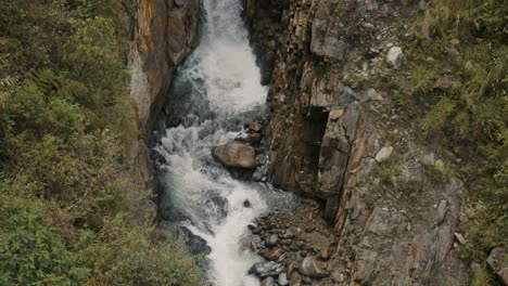 Water-flowing-through-the-river-from-waterfalls-in-Baños-de-agua-santa,-Ecuador