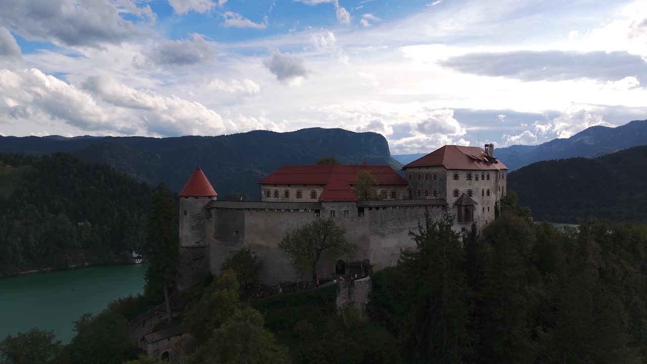 Aerial Tilt up Lake Bled Island and Bled Castle with Tourists Exploring Slovenia