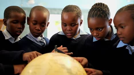 schoolkids using globe in classroom 4k