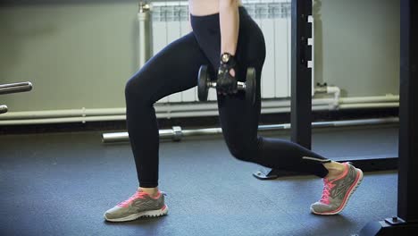Woman Performing Dumbbell Lunges in Gym