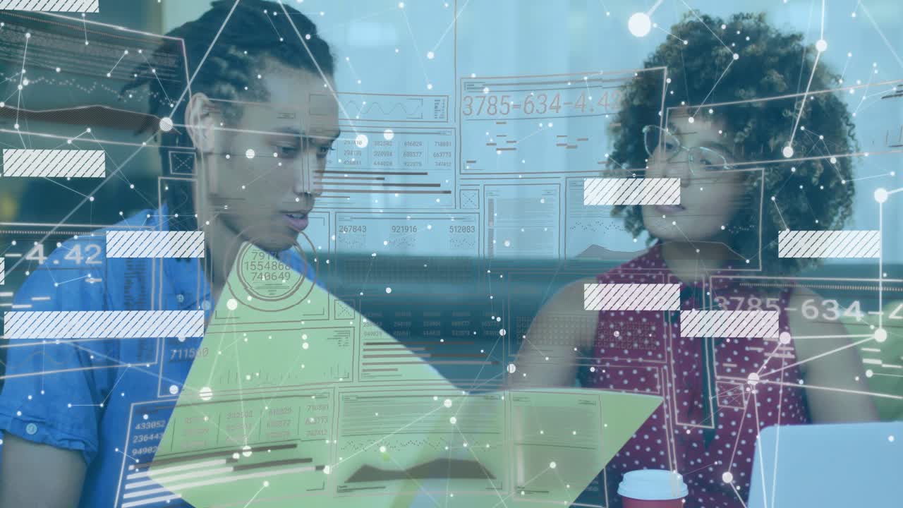 Two colleagues reviewing documents at conference table showing technology with network overlays