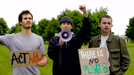 three male friends in a protest using a megaphone