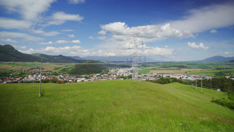 Grünes-Gras-Auf-Der-Wiese,-Die-Vom-Wind-Weht,-Mit-Fernmeldeturm-Und-Der-Stadt-Ruzomberok-In-Der-Ferne-In-Der-Slowakei