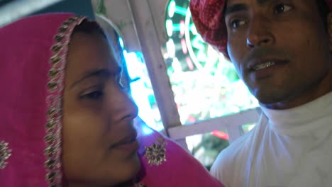 indian couple enjoying ferris wheel ride in traditional dresses at the pushkar mela, a carnival of rajasthan, india
