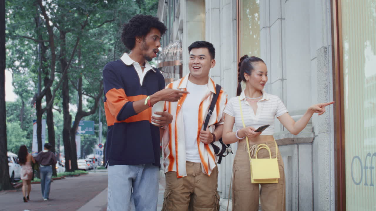 Multicultural Friends Looking at Shopwindows during City Walk