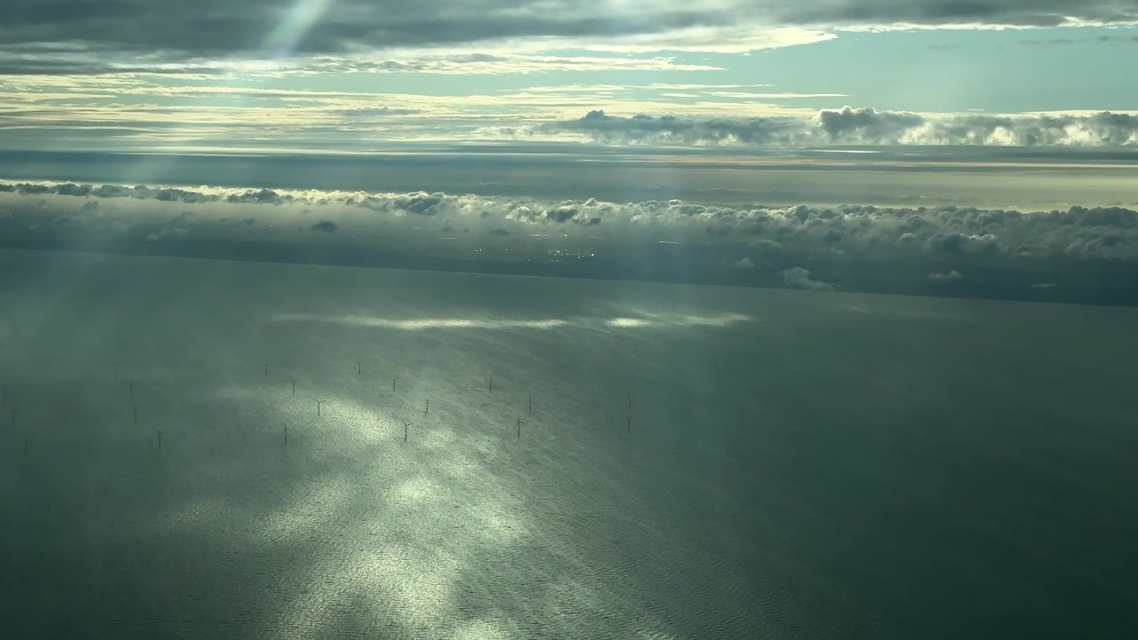 Aerial shot of a windmill park in the North Sea off the coast of the Netherlands, shot from an airplane