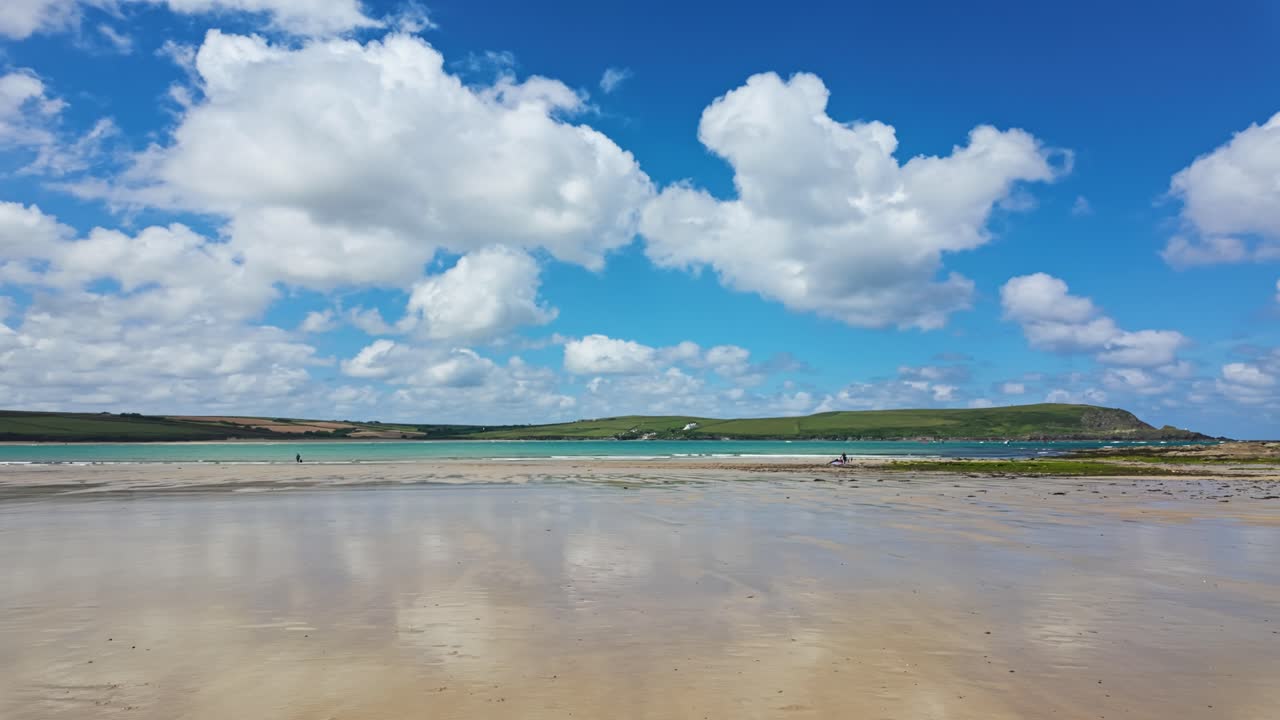 pan, de derecha a izquierda desde la bahía de daymers, playa con reflejo de nubes en la arena húmeda en la marea baja