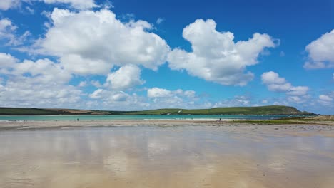 pan, right to left from daymers bay, beach with reflection of clouds in wet sand at low tide