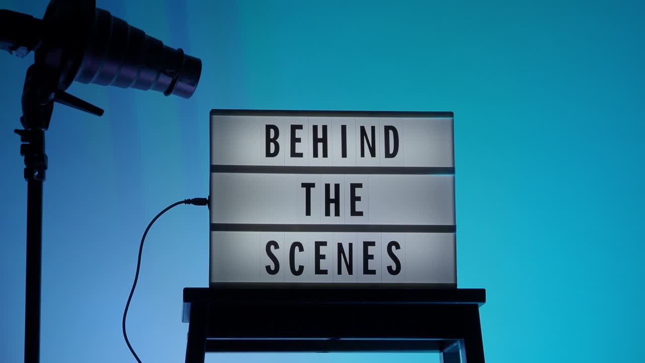 영화관 라이트 박스. 무대 뒤에 라이트 박스에 있는 레터보드 텍스트. 배경 리드 컬러 변경 루프. 트라이포드에 있는 스누트 후드 플래시. 비디오 프로덕션 스튜디오의 정적 카메라.