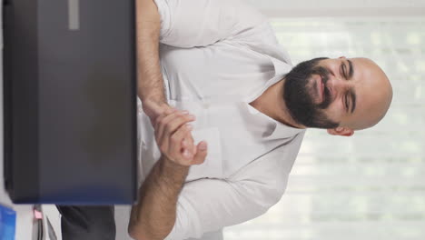 Vertical-video-of-Home-office-worker-man-applauding-what-he-sees-on-laptop.