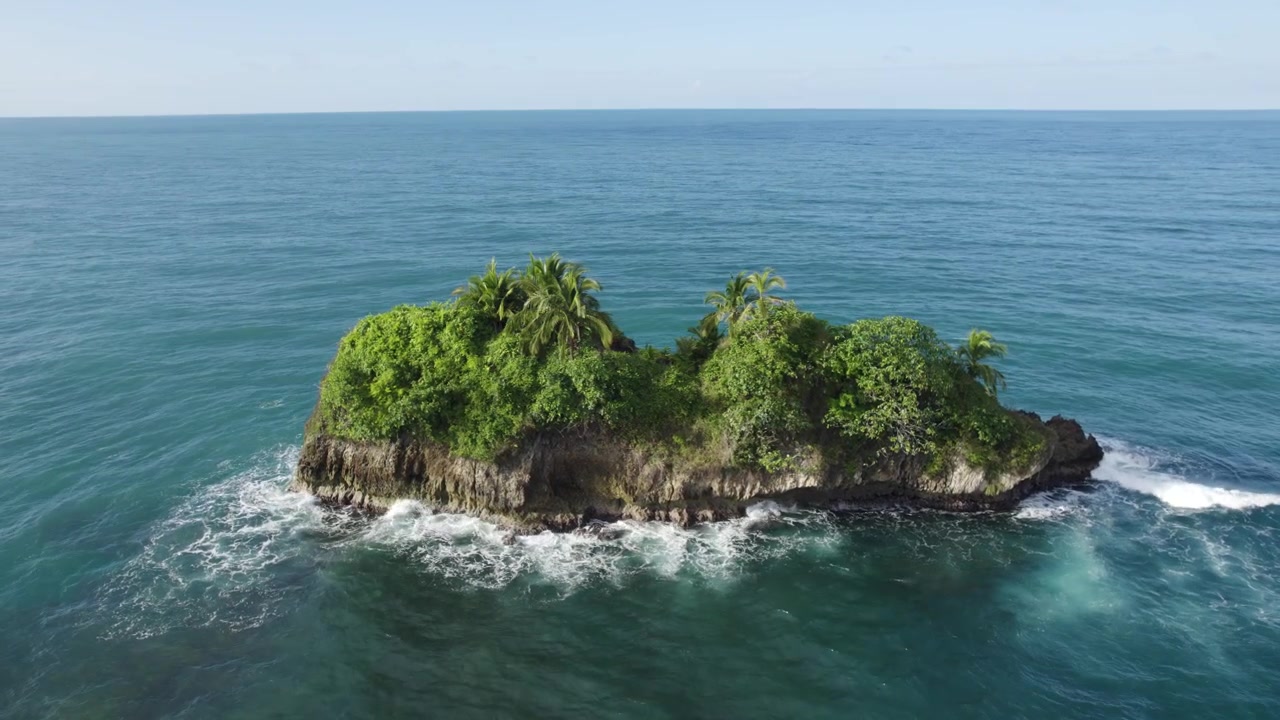 Vista aérea de una pequeña isla cerca de Playa Cocles en la provincia de Limón de Costa Rica, rodeada de aguas oceánicas cristalinas. Movimiento orbital.