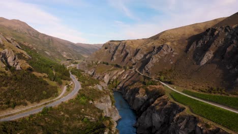 south island, nz aerial of winding road, river canyon and vineyard, rural area