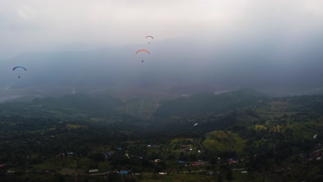 Drei-Gleitschirme-Fliegen-über-Die-Nepalesische-Landschaft