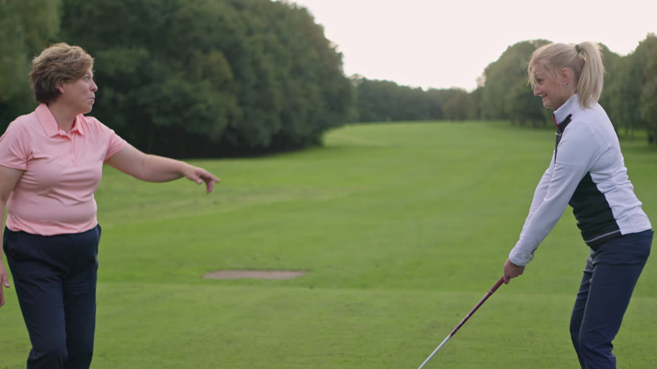 Two women playing golf on a course