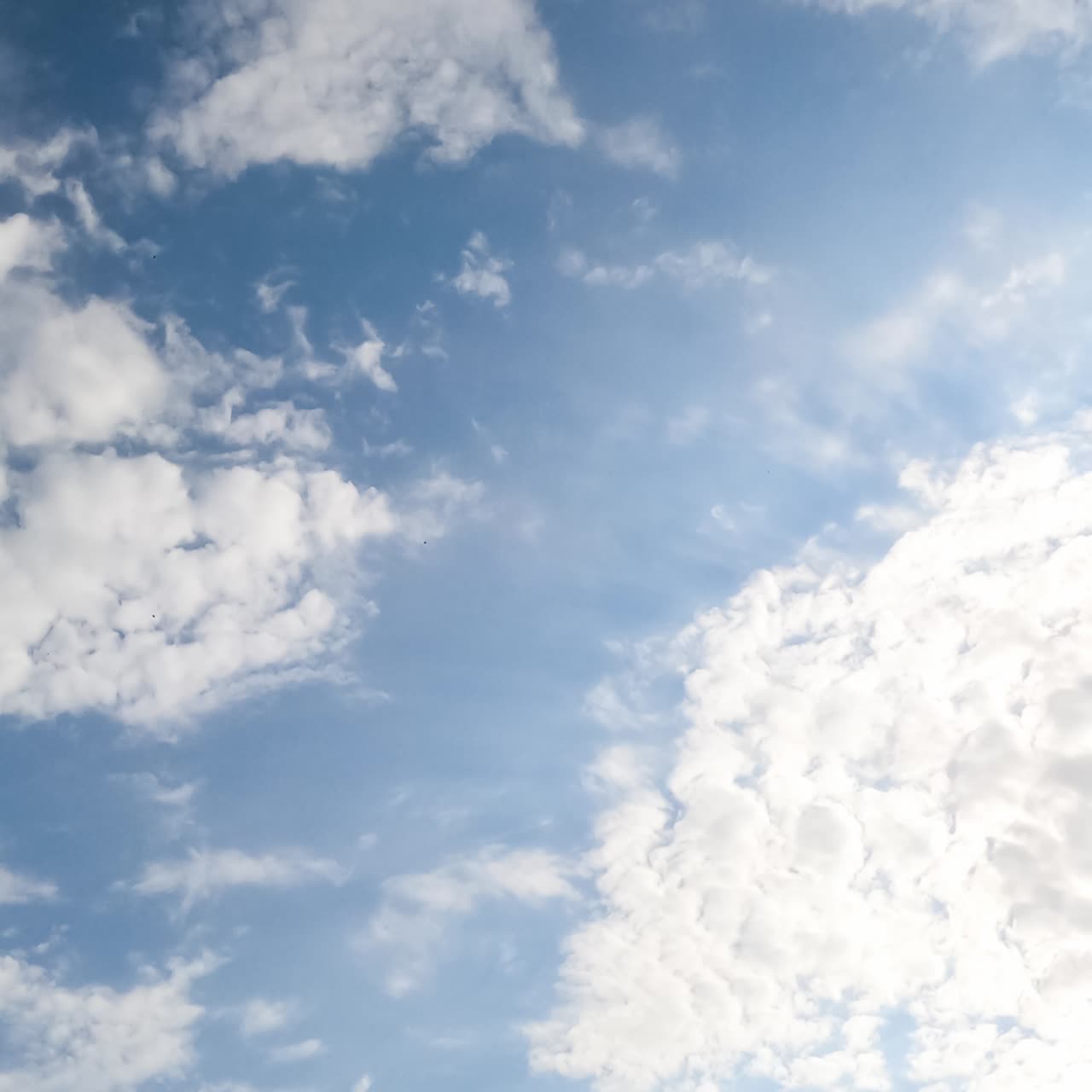 Slow transformation of spindrift clouds in the atmosphere. White clouds covering the skies low angle view. Timelapse