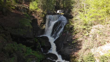 Water-running-from-the-Triberg-waterfall,-located-in-the-Black-Forest-in-middle-of-the-green-mountain-during-summer-sunny-day