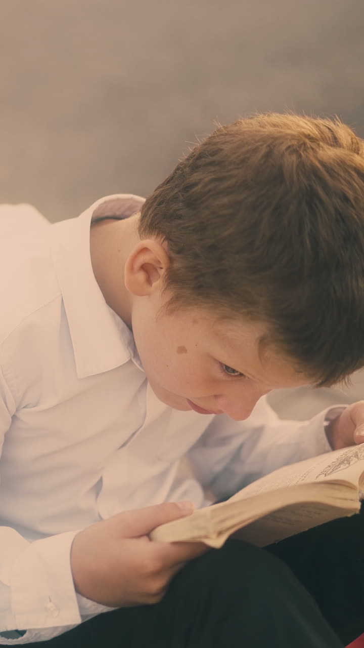 beautiful children brothers sister prepare for exam sitting on grey pavement and read textbooks in free time close view