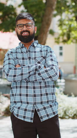 happy indian man smiling looking at camera dreaming resting good news feel satisfied in city street