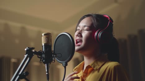 young asia woman singing in recording studio