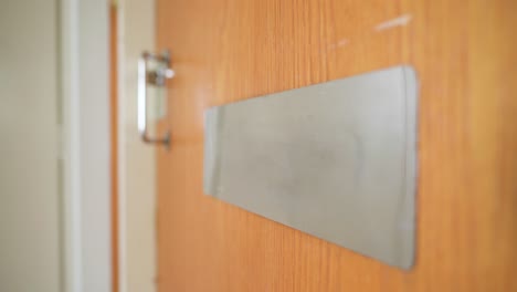 white envelope being dropped through a mail slot in the door