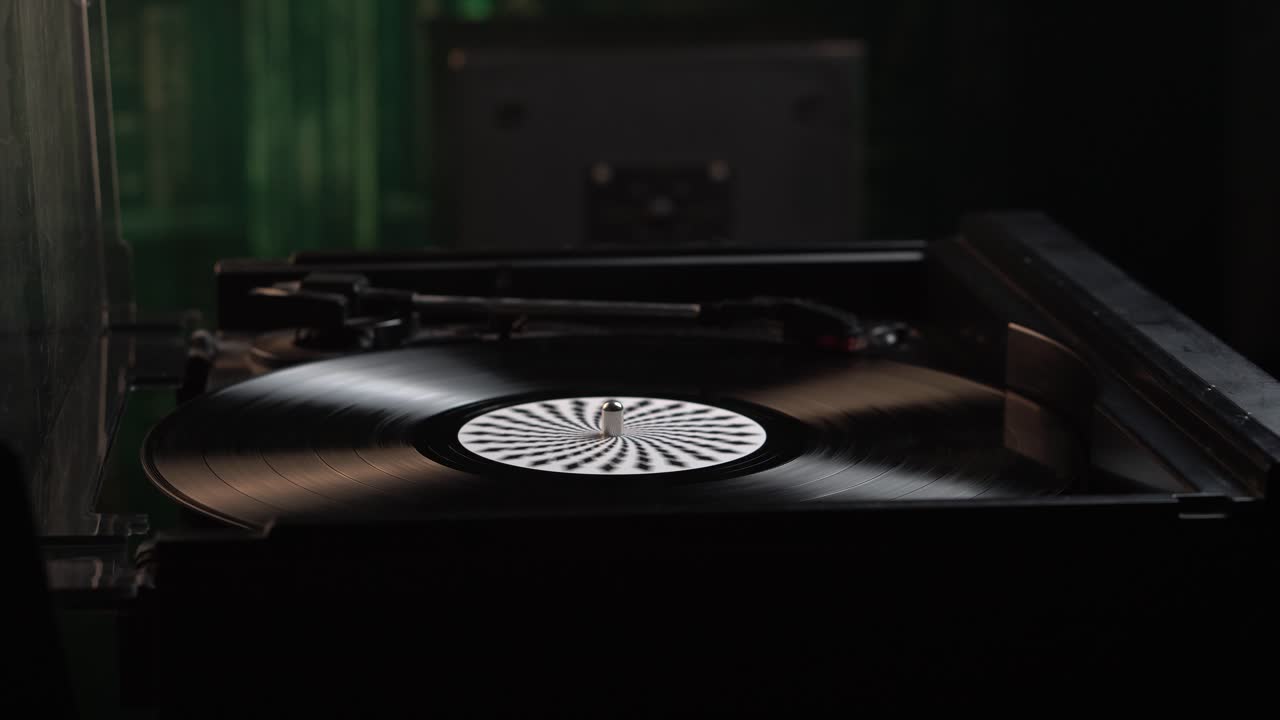 Sætter en vintage vinylplade på pladespilleren og placerer nålen på den snurrende plade
