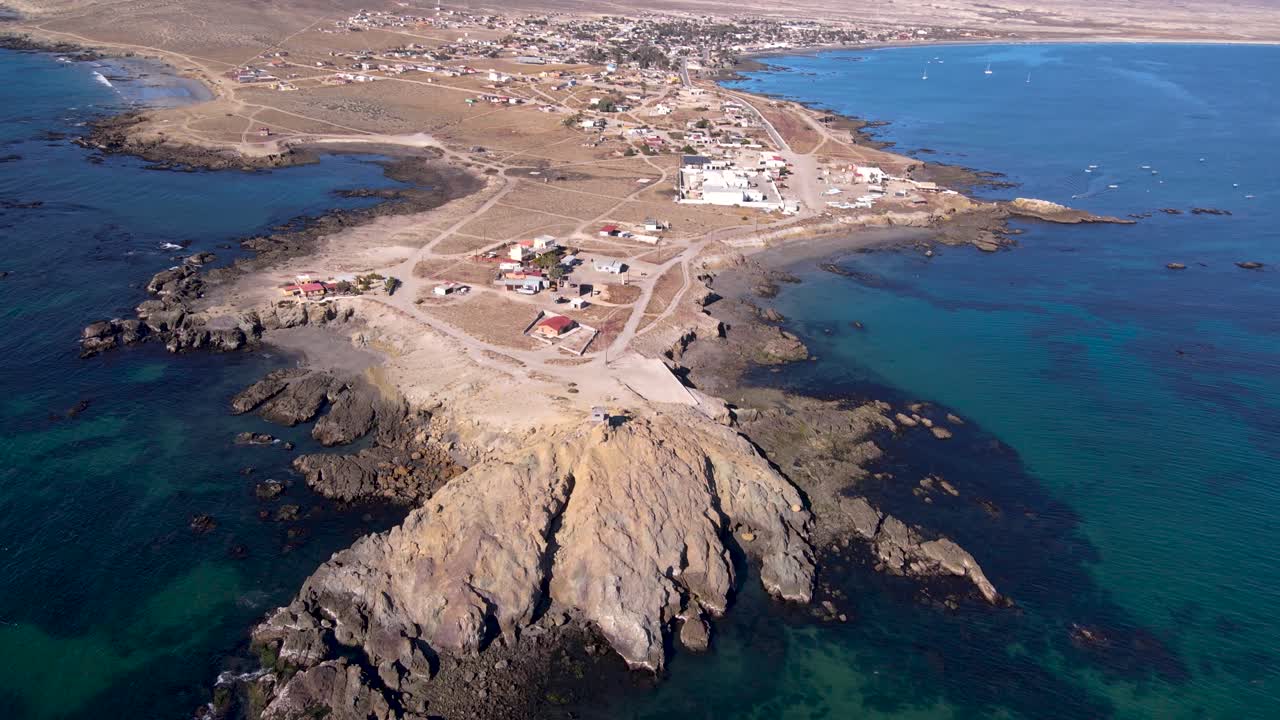 línea costera rocosa de la península de bahía asunción y ciudad en un día soleado