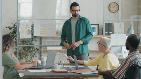 hombre de negocios dando una presentación a un equipo diverso en una reunión de oficina