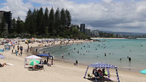 crowded beach scene with evolving cloud cover