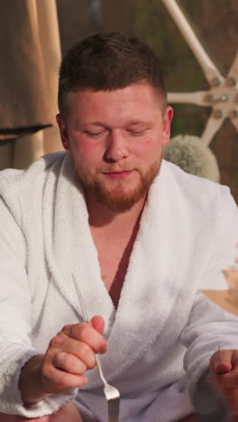 man eats breakfast with wife in round glamping house. bearded boyfriend offers piece of pancake to beloved woman in hotel. morning romantic date