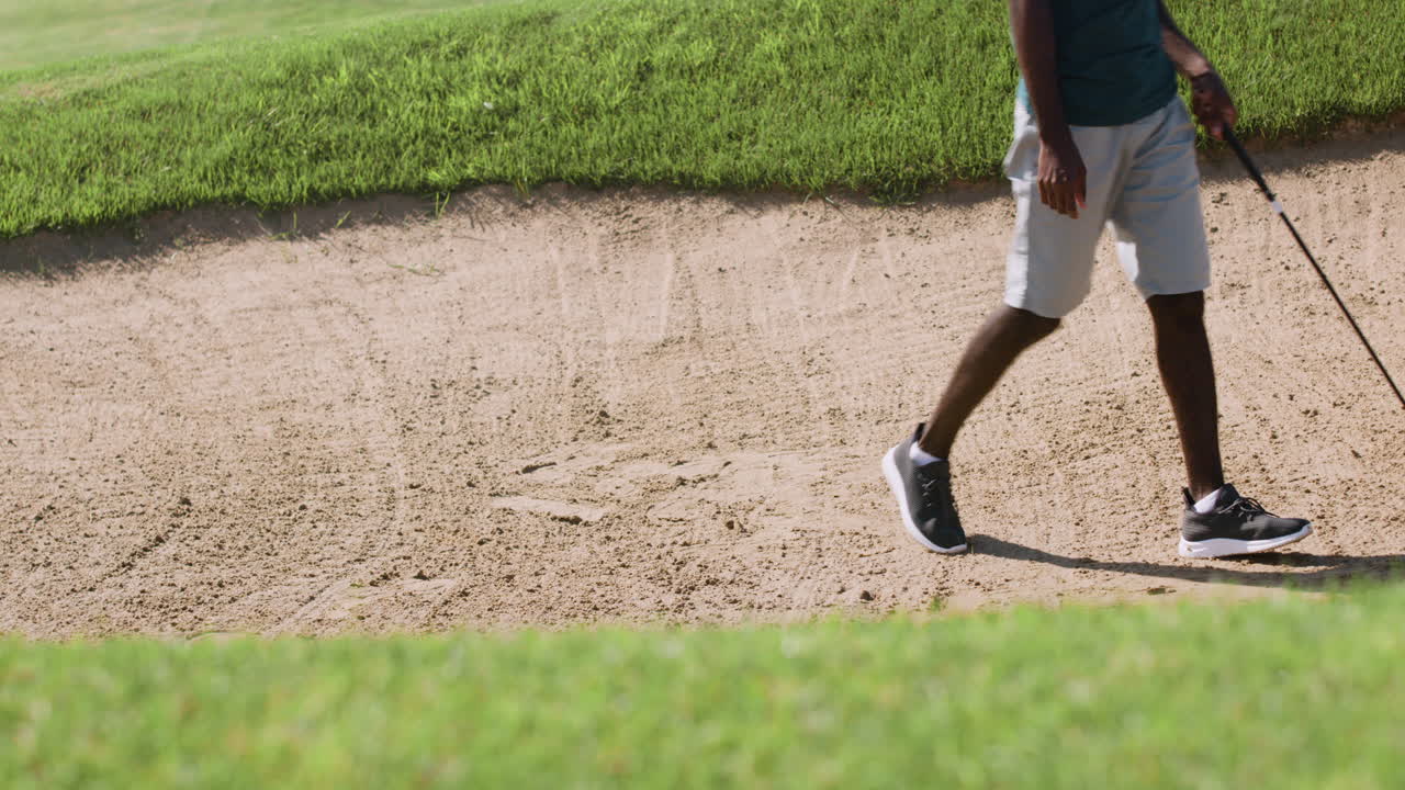 아프리카계 미국인이 골프장에서 골프를 연습하고 있습니다.