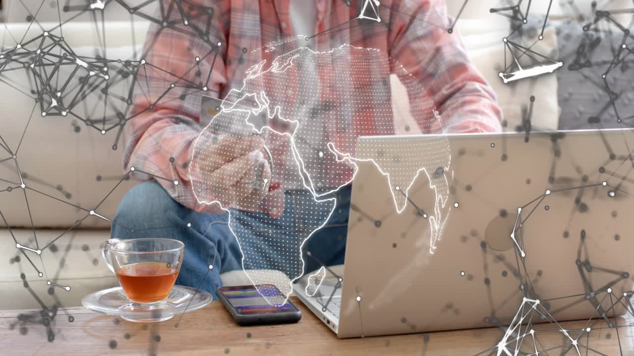 Man lifting card tapping phone causing globe nodes moving receding on laptop paying lowering card