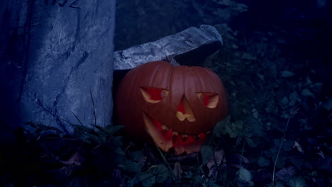 halloween pumpkin by tombstone, flashing light and fog, horror atmosphere, slider closeup shot