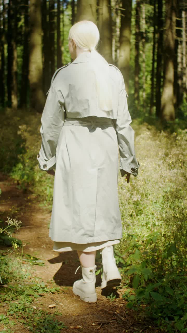 Woman in Trench Coat Walking in Forest