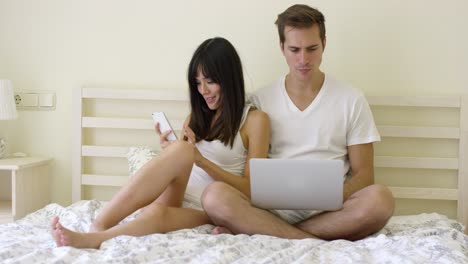 joven pareja seria sentados juntos en la cama
