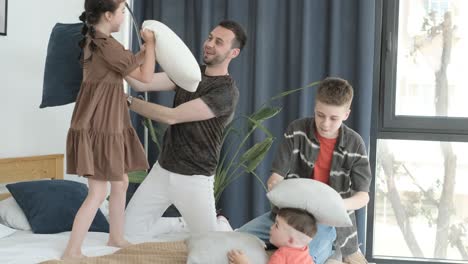 smiling family having fun with pillows in their bedroom full of laughter and smiles. smiling family having fun with pillows in their bedroom, full of laughter and smiles