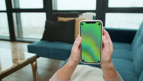 woman scrolling on smartphone at home