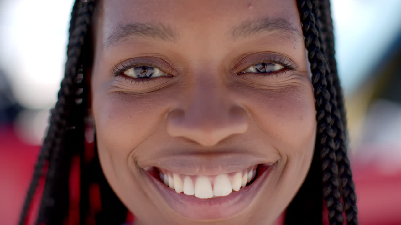 Close-up de uma jovem mulher afro-americana sorrindo abertamente em uma viagem de carro.