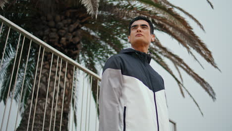 ajuste corredor chaqueta con cremallera en el ejercicio al aire libre. hombre enfocado escuchando auriculares