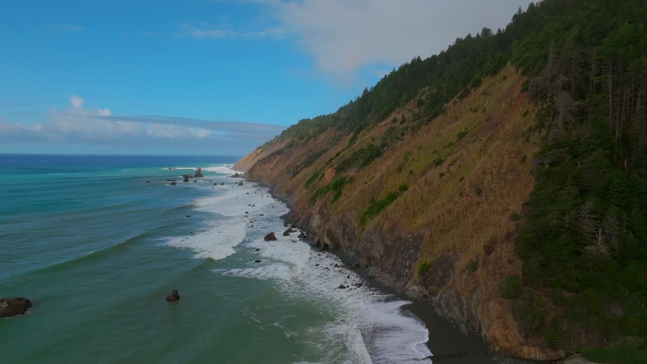 Rugged Coastline Shoreline Pacific Coastal Highway 1 DeHaven Westport Fort Bragg aerial drone California blue sky surf waves crashing boulder rocks mountain side Pacific Ocean forward motion