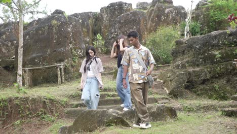 young asian friends walking on forest footpath in nature