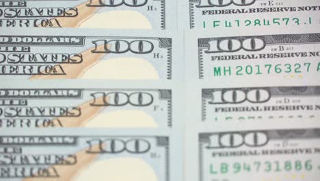 many dollars dollars dollars closeup. the camera spans from above over evenly placed bills. 100 dollars