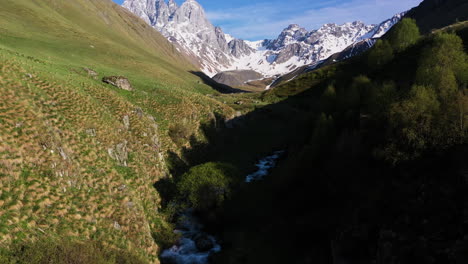 disparo de drones siguiendo un arroyo de montaña y luego subiendo para revelar los dolomitas georgianos en las montañas del cáucaso