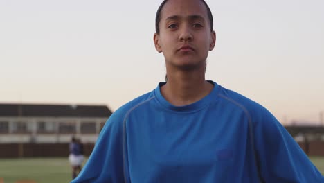 portrait of young adult female rugby player on a rugby pitch