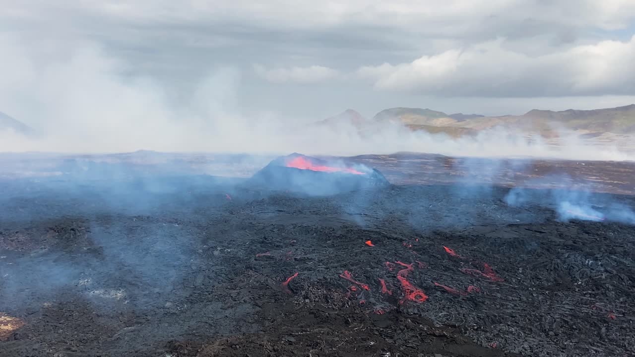 Active volcano crater with smoke covered magma field, Iceland