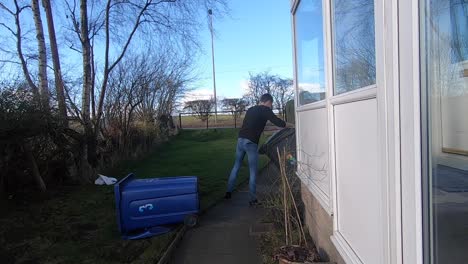 Caucasian-man-picking-up-rubbish-bins-that-have-fallen-over