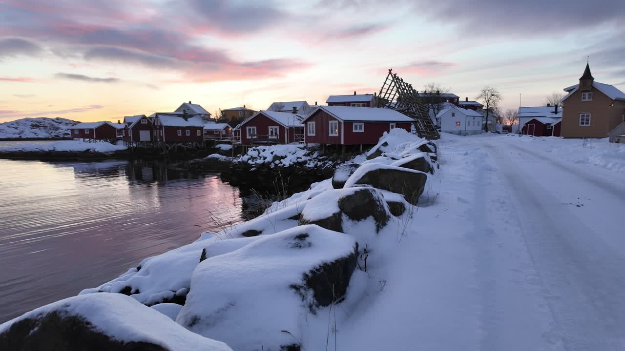 ノルウェー、スヴォルヴァーの夕暮れ時、パステルカラーの空の下に広がる雪に覆われた沿岸の町、冬の静寂