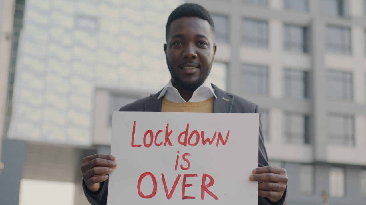 Man Holding Sign Saying 'Lock Down is Over'