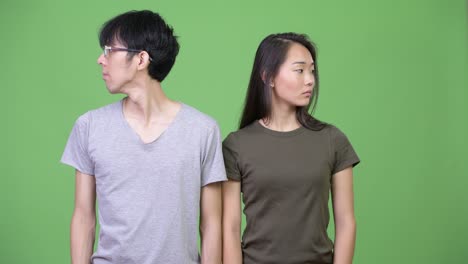 young asian couple looking away together