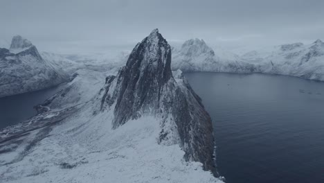 Vista-Aérea-De-Drones-Acercándose-A-La-Montaña-Nevada-De-Segla,-Hora-Azul-En-Senja,-Noruega