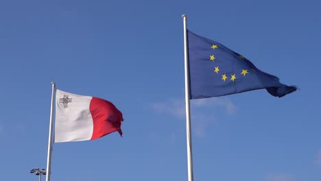 Malta--Und-Eu-flaggen,-Die-In-Zeitlupe-Am-Klaren-Blauen-Himmel-Im-Wind-Wehen